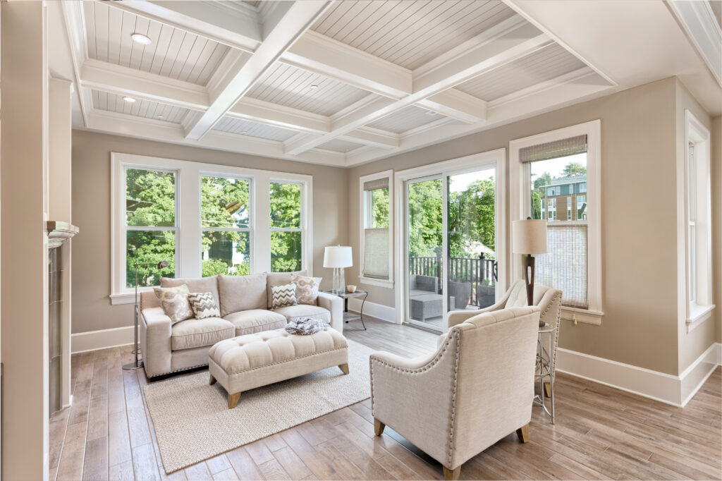 Living room with a coffered ceiling, white trim and tall windows