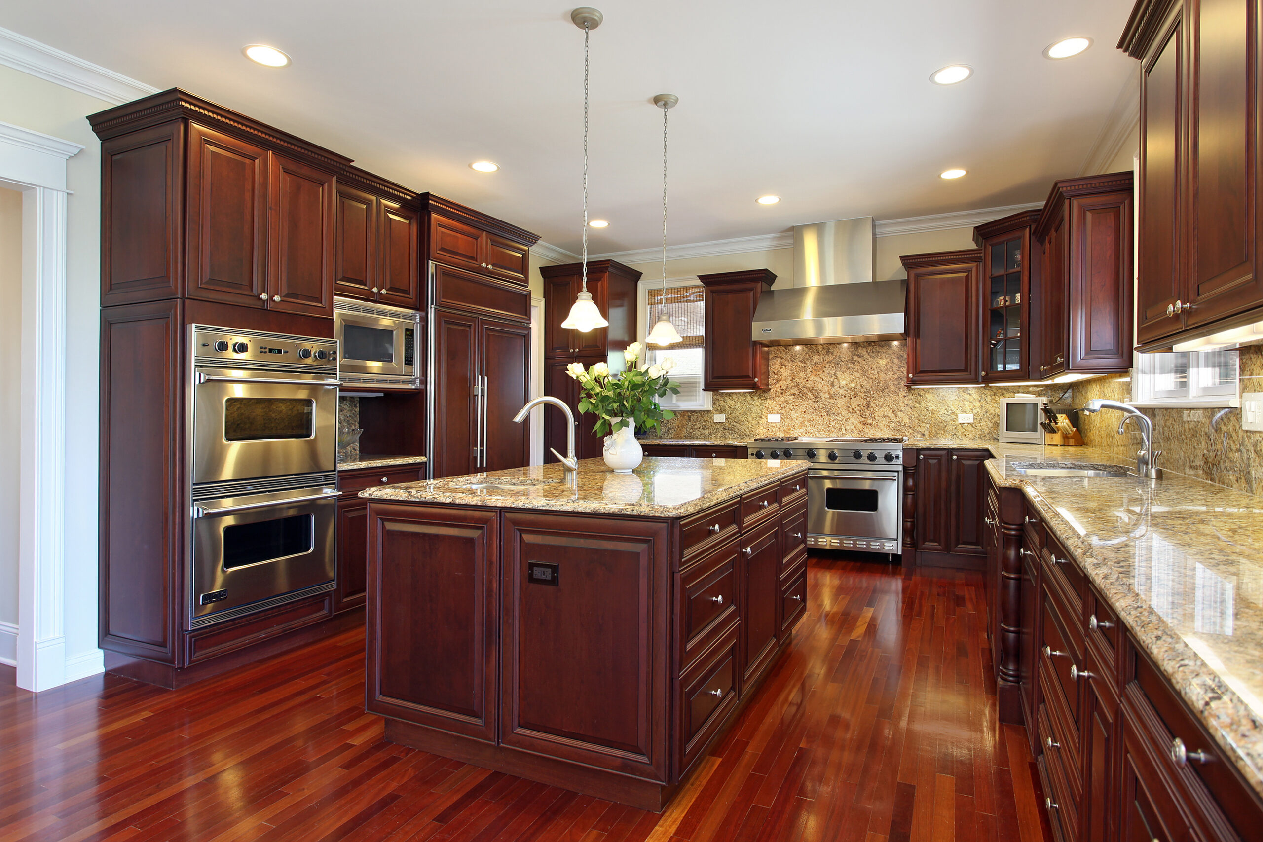 Kitchen with cherry wood cabinetry and stone countertops, wide view