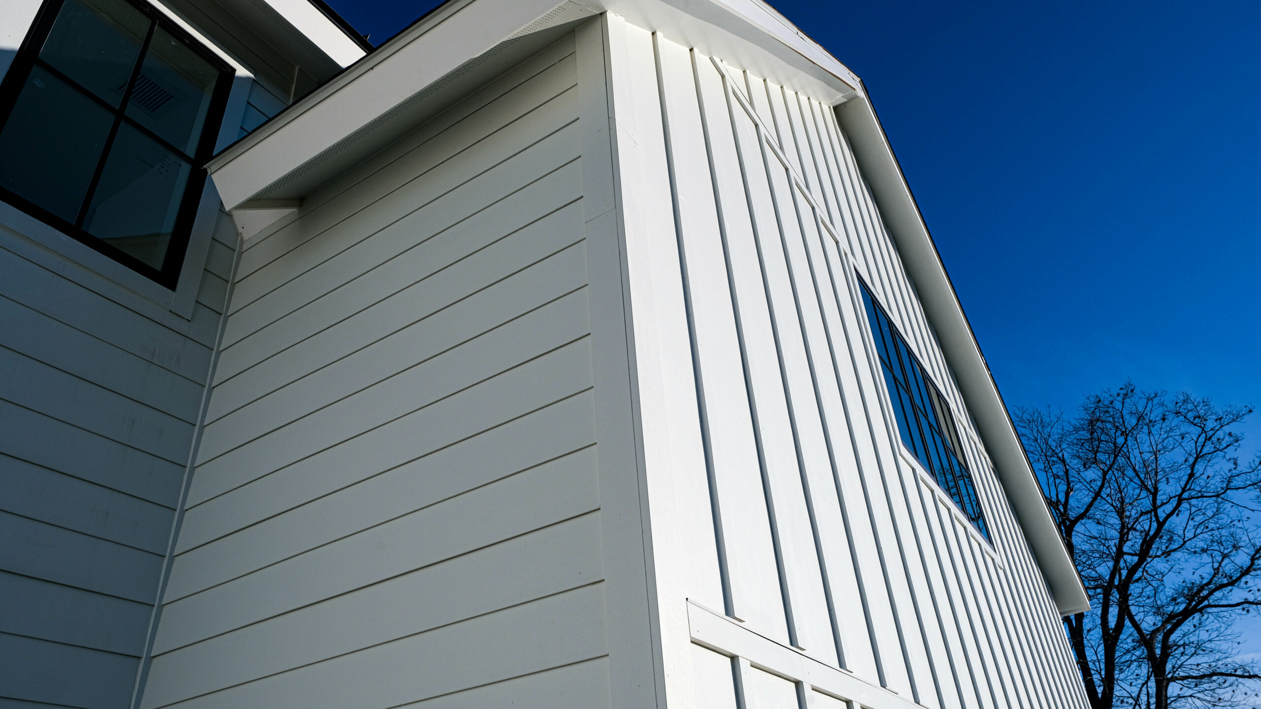 White fiber cement lap siding and board-and-batten on a farmhouse gable