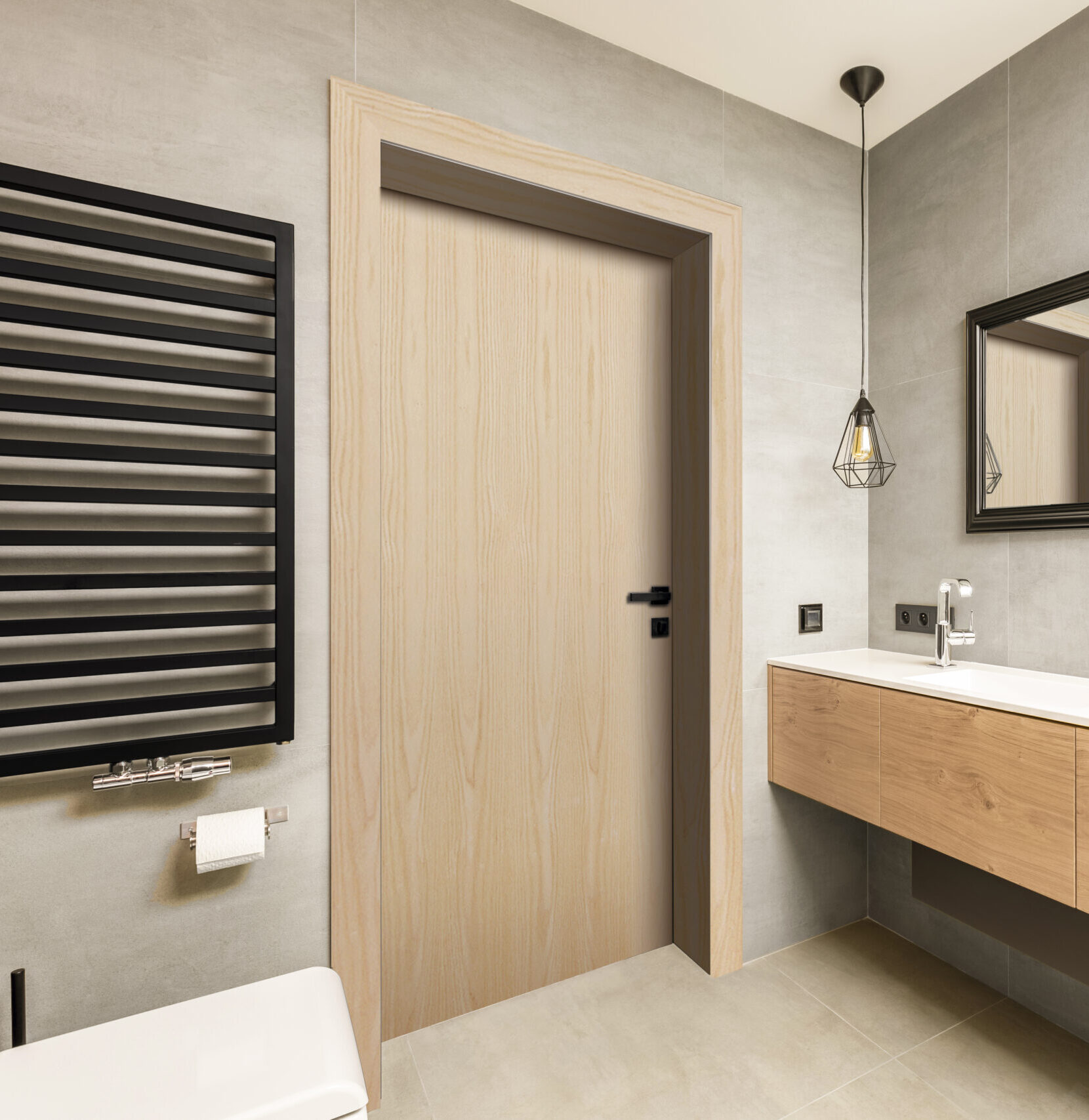 Modern bathroom with a flush light birch door, floating vanity and black towel radiator