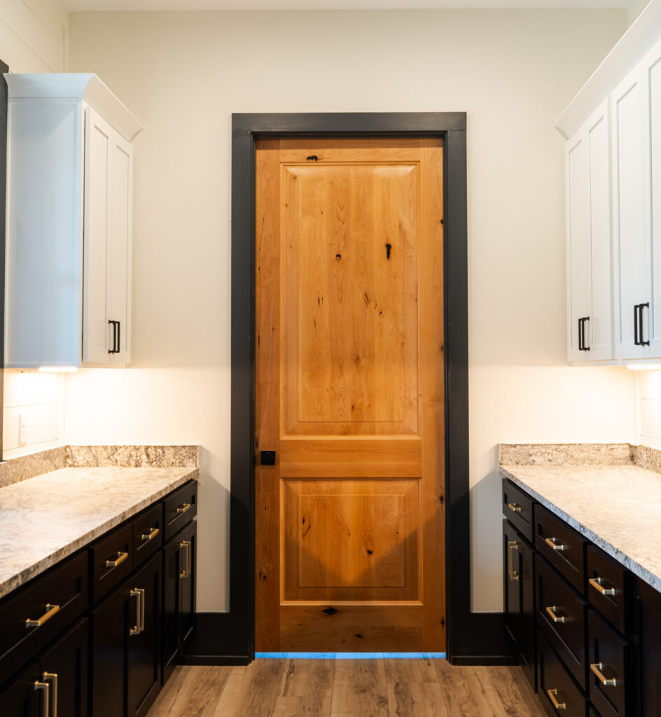 Knotty alder single-panel interior door with black trim in a butler's pantry