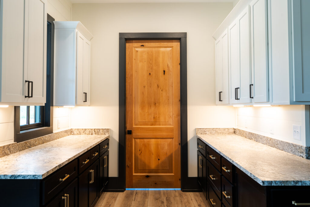Knotty alder single-panel interior door with black trim in a butler's pantry