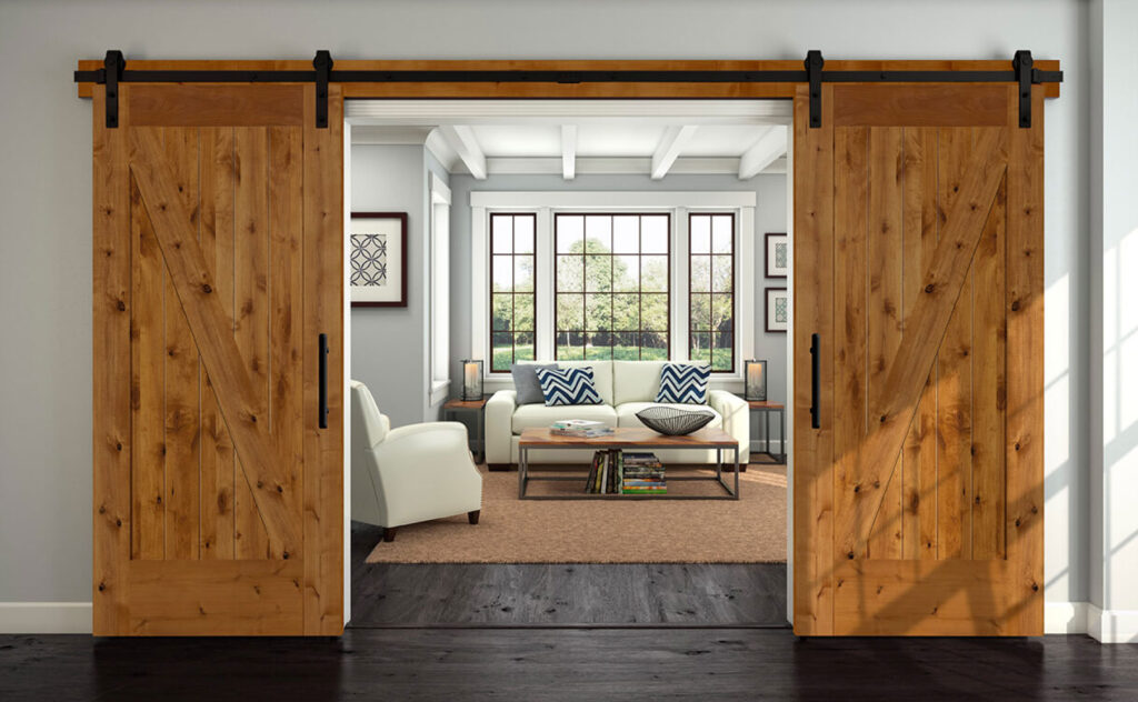 Pair of knotty alder barn doors on black rails opening onto a living room