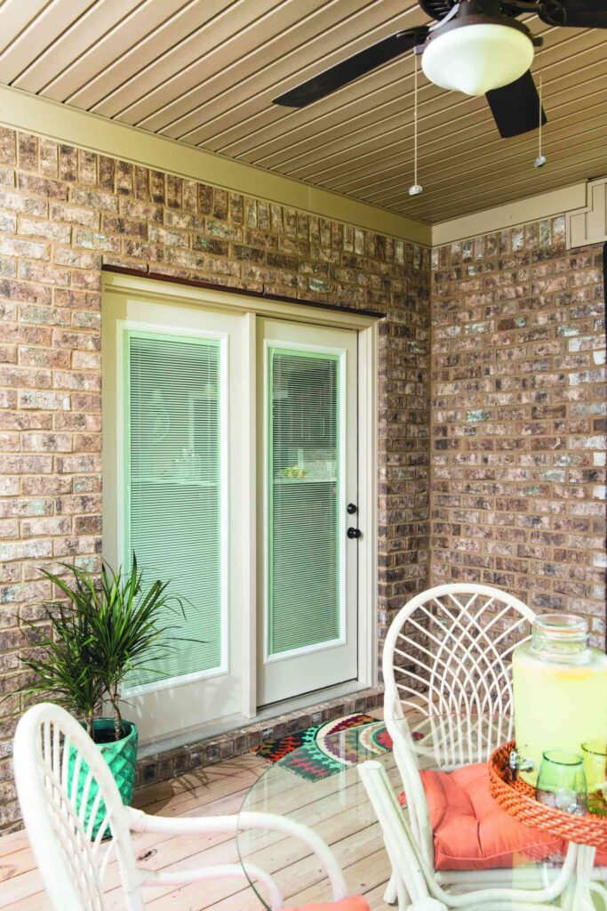 Brick covered porch with white French patio doors with internal blinds