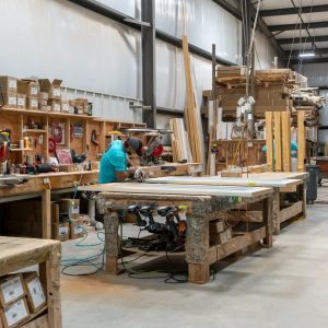 Workshop with long workbenches and a worker assembling doors